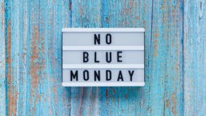 "No Blue Monday" sign on blue wooden slats